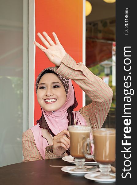 Beautiful Muslim girl waving to her friend