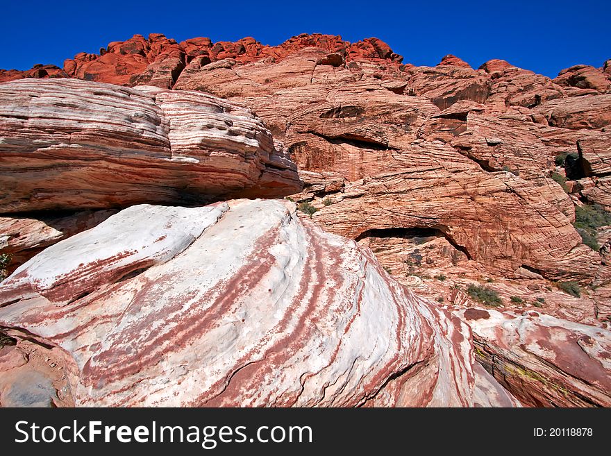 View of dry landscape and red rock formations of the Red Rock Canyon in the Mojave Desert. View of dry landscape and red rock formations of the Red Rock Canyon in the Mojave Desert.