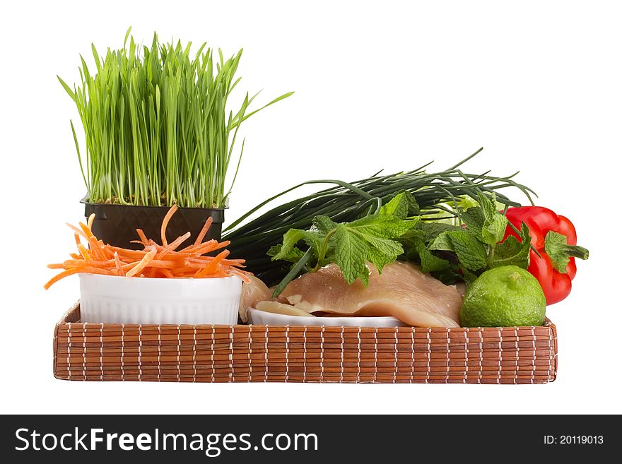 Raw chicken breast and vegetables on a brown tray. Raw chicken breast and vegetables on a brown tray.