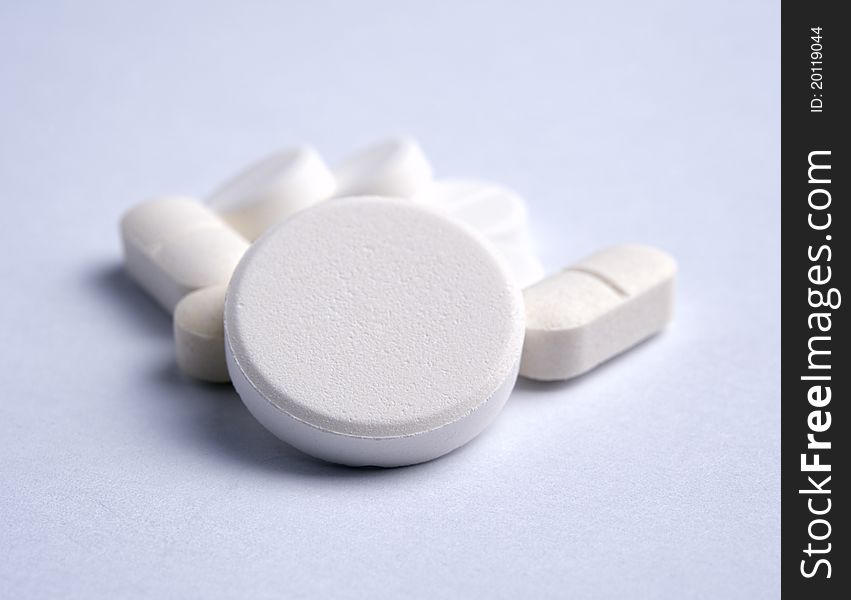 Some of White pills on a light background Shallow DOF