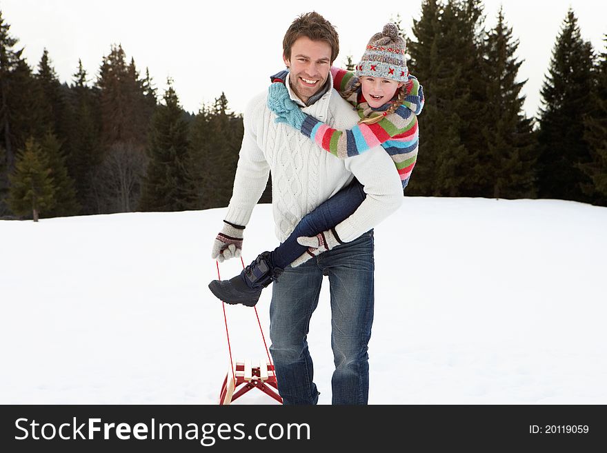 Young Father And Daughter In Snow With Sled having fun