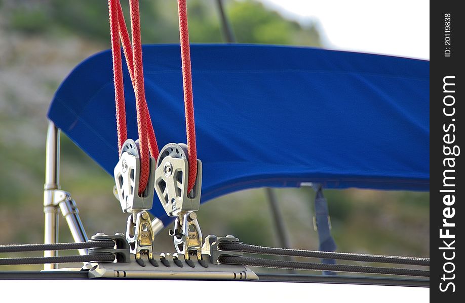 Sailing rigging. Blocks and red cords. Detail of yacht. Ropes of sailboat - tackles on the rigging yacht. Yachting equipping - pulleys blocks.