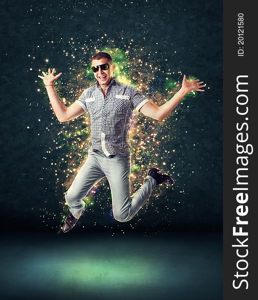 Jumping smiling young man on glowing abstract background. Jumping smiling young man on glowing abstract background
