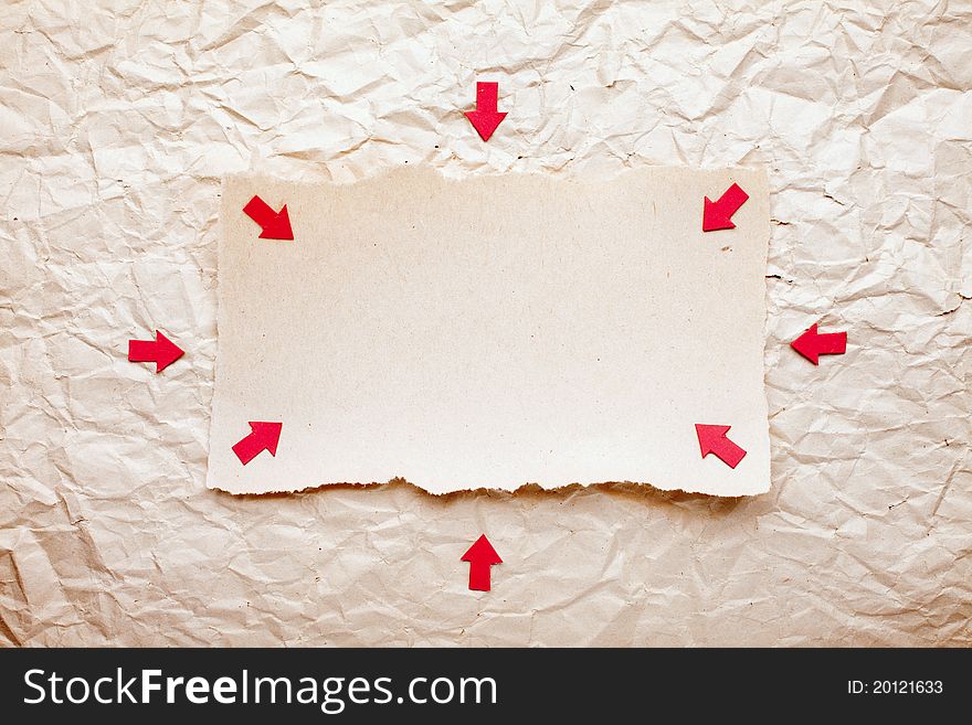 Ripped piece of paper with red arrows on old crushed paper background. vintage retro card