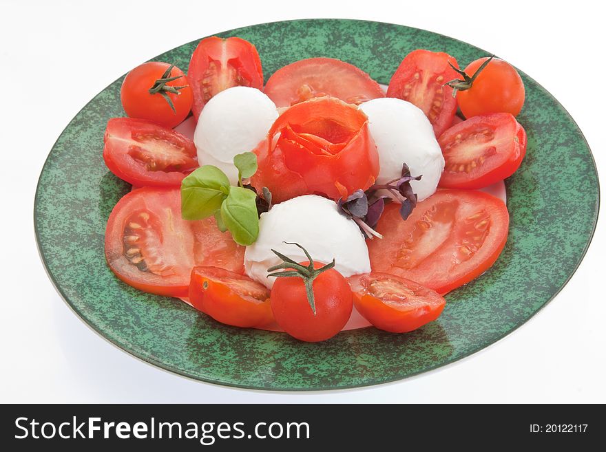 A Caprese salad consisting of sliced tomatoes, mozzarella cheese and garnished with a tomato rose, basil leaves & purple basil shoots. A Caprese salad consisting of sliced tomatoes, mozzarella cheese and garnished with a tomato rose, basil leaves & purple basil shoots