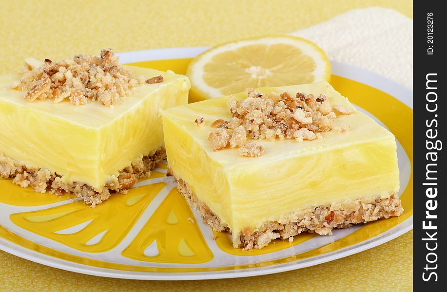 Two lemon square with a lemon slice on a plate. Two lemon square with a lemon slice on a plate