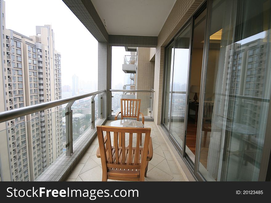 Balcony of an apartment with chairs and table in Shanghai.