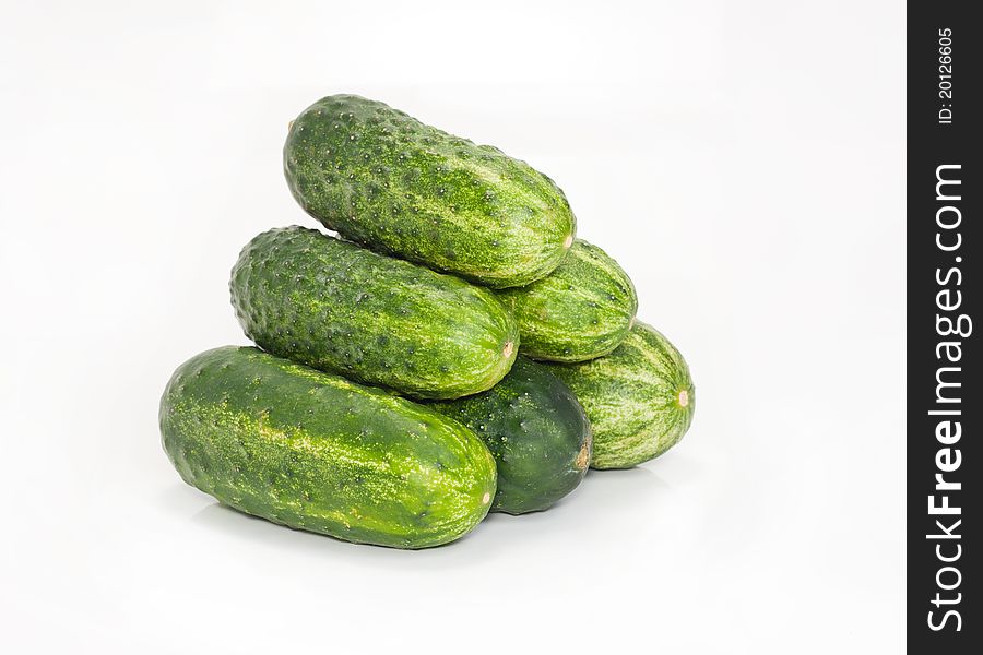 Small group of green cucumbers is isolated on a white background