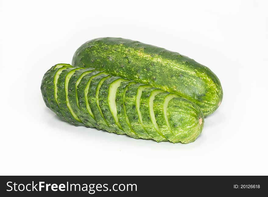 Cut and whole green cucumbers isolated on a white background