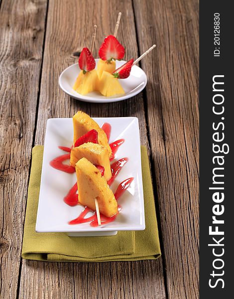 Pineapple and strawberry skewers garnished with sweet sauce. Pineapple and strawberry skewers garnished with sweet sauce