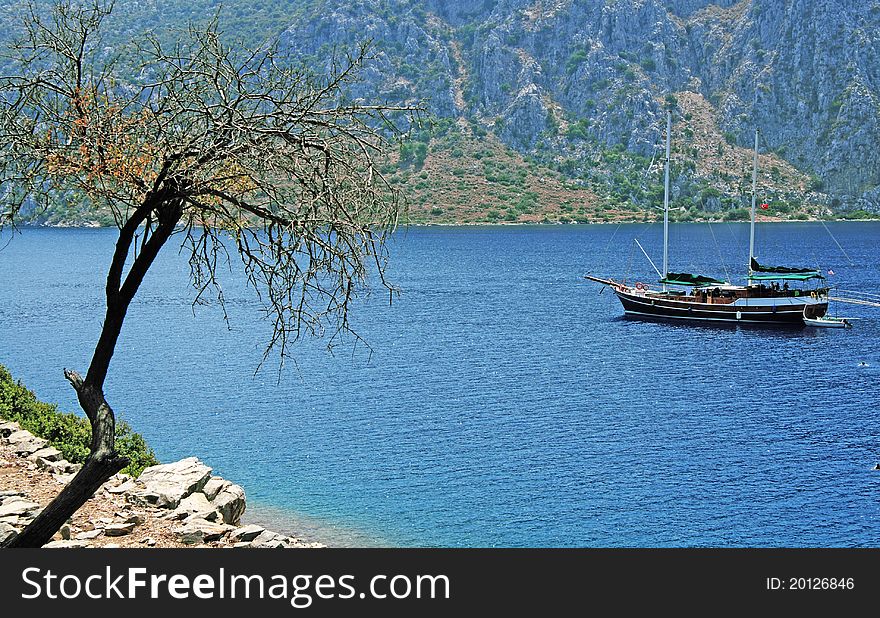 Sailboat at sea, on background rock. Sailboat at sea, on background rock