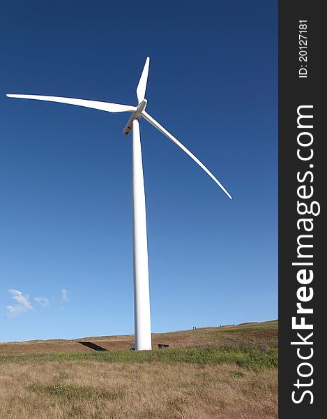 A wind turbine stands tall in a field. A wind turbine stands tall in a field.