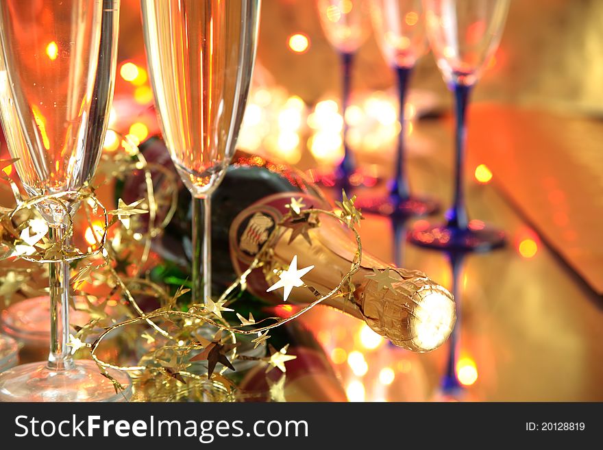 Close-up of champagne in glasses ,bottle and twinkle lights on background.