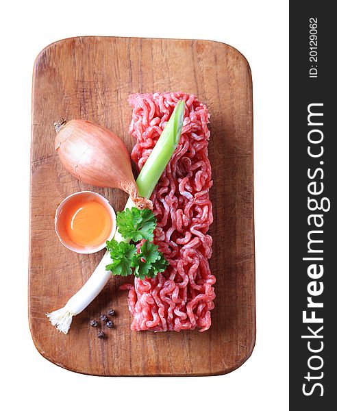 Raw minced meat and other ingredients - overhead, cut out on white
