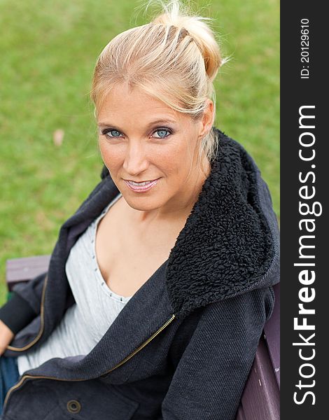 Young attractive woman relax in the park with her jacket on