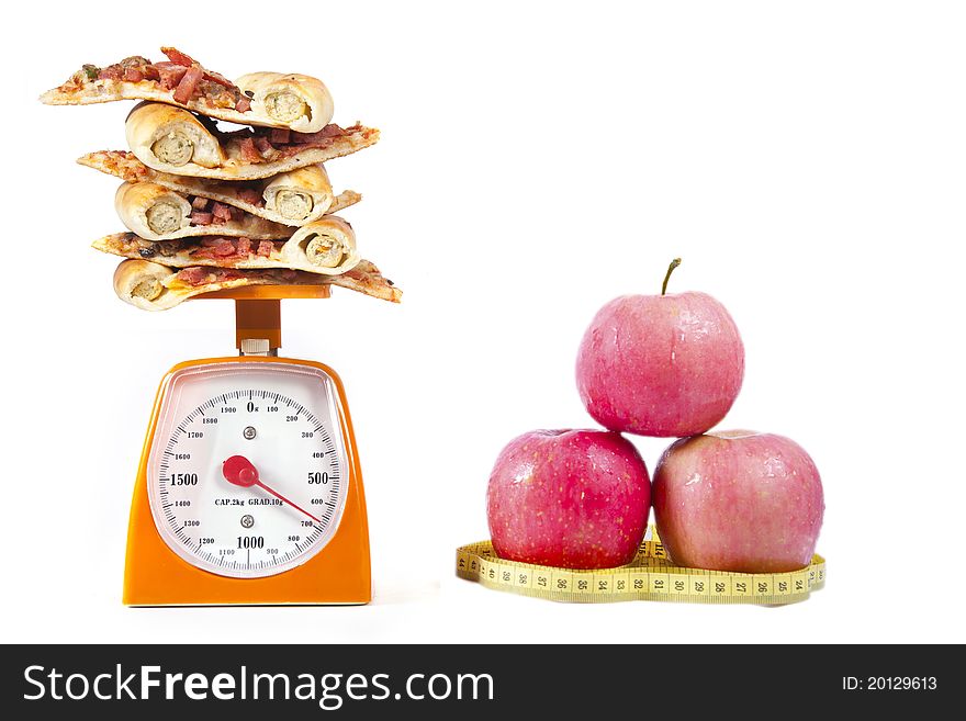 Photo of pizza slices stacked on a scale with an Apple isolated over white. Photo of pizza slices stacked on a scale with an Apple isolated over white