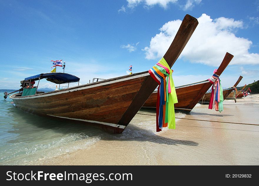 Longtail boats with colorful ribbons beached in Thailand