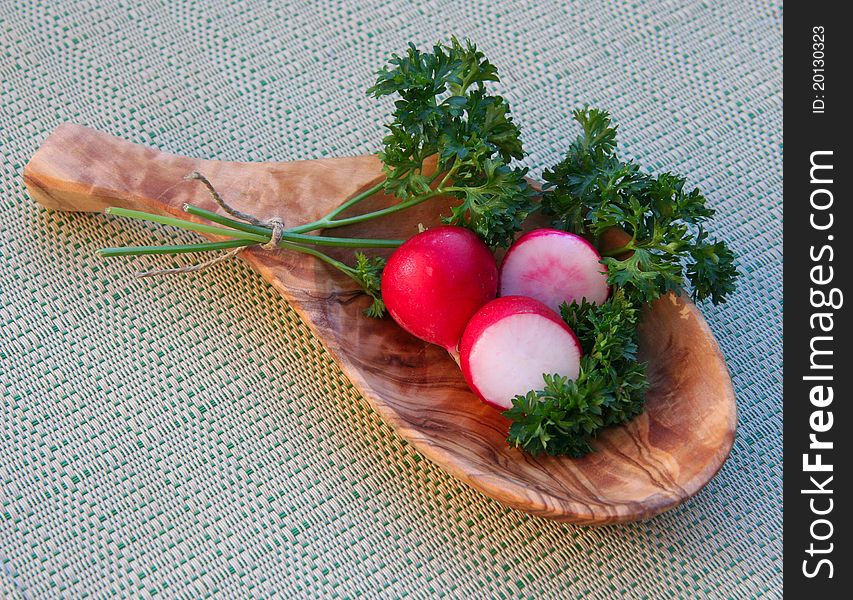 Wooden tray with fresh radish and parsley