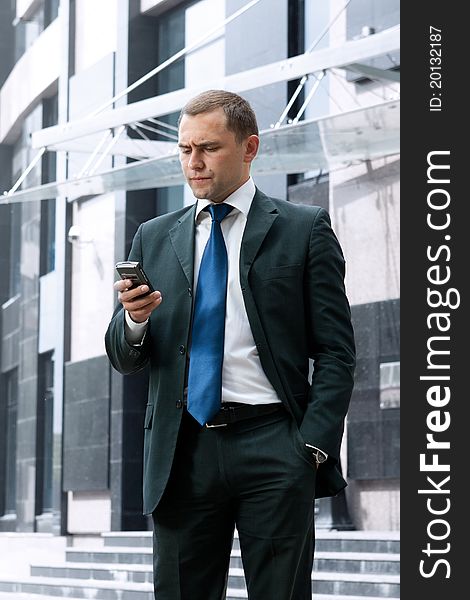 Young and successful businessman is reading a message on his smartphone