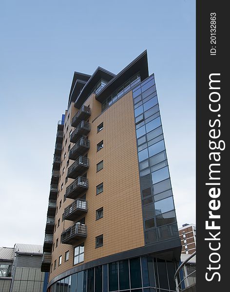 A Twenty First Century Stylish Glass and Brick Apartment Block against a blue sky. A Twenty First Century Stylish Glass and Brick Apartment Block against a blue sky