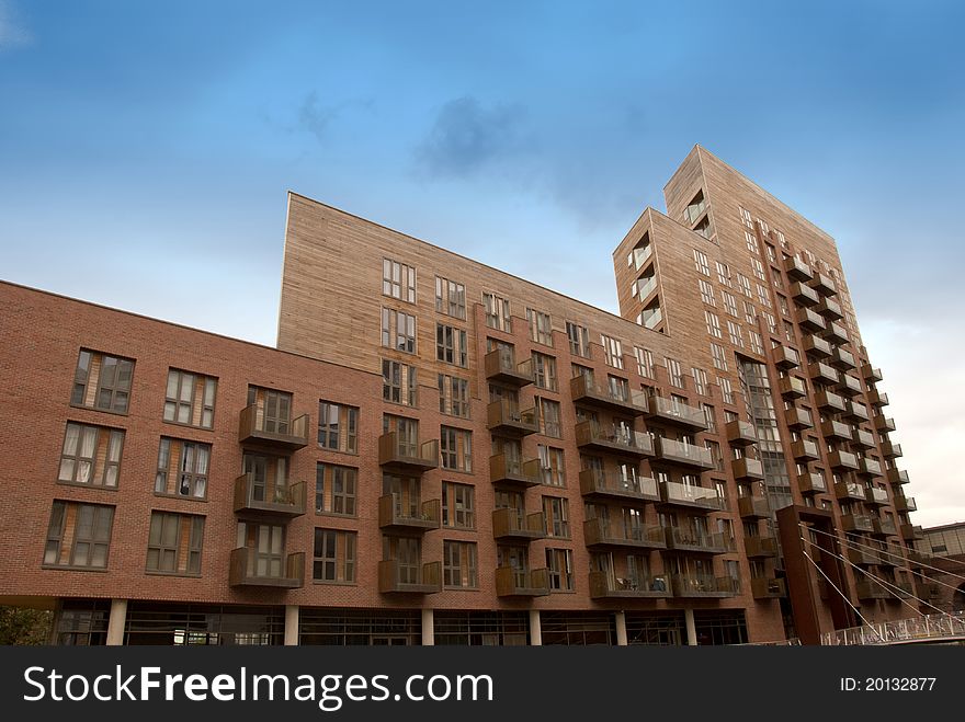 A Large Red Apartment Block under a blue summer sky