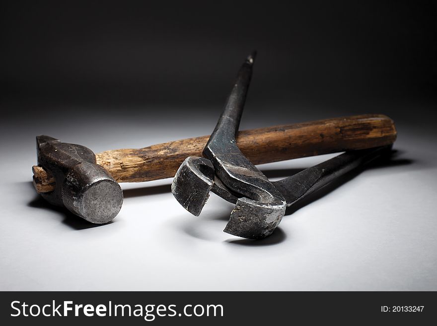 Hammer and pincers on the black-white gradient background. Hammer and pincers on the black-white gradient background