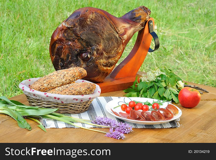 Ham on the table with tomato, bread and decoration, outdoor photo. Ham on the table with tomato, bread and decoration, outdoor photo.