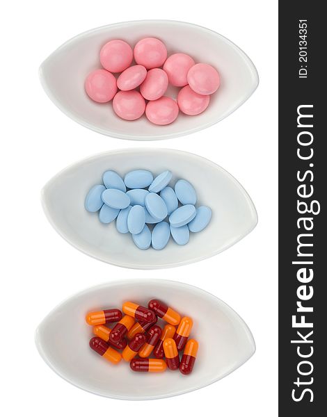 Three ceramic bowls with color pills, isolated. Three ceramic bowls with color pills, isolated