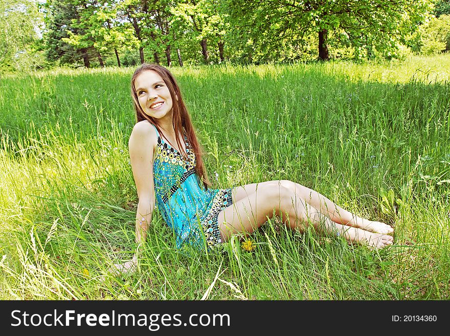 Young girl sits on the glade in the park. Young girl sits on the glade in the park