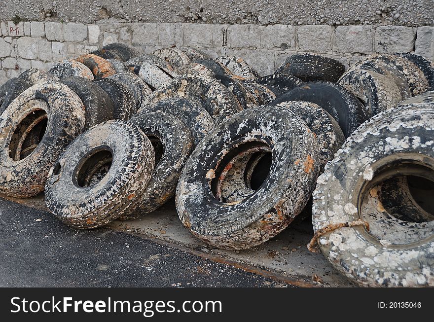 Wasted tyres layed on the wall in a harbor. Wasted tyres layed on the wall in a harbor