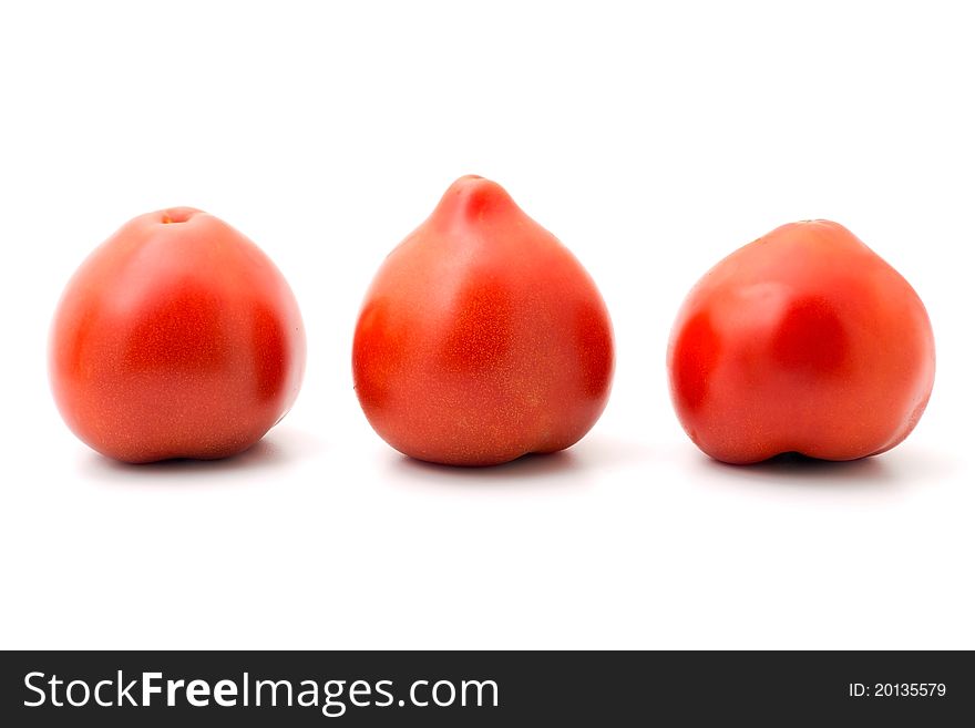 Three ripe tomatoes lined up in a row on white