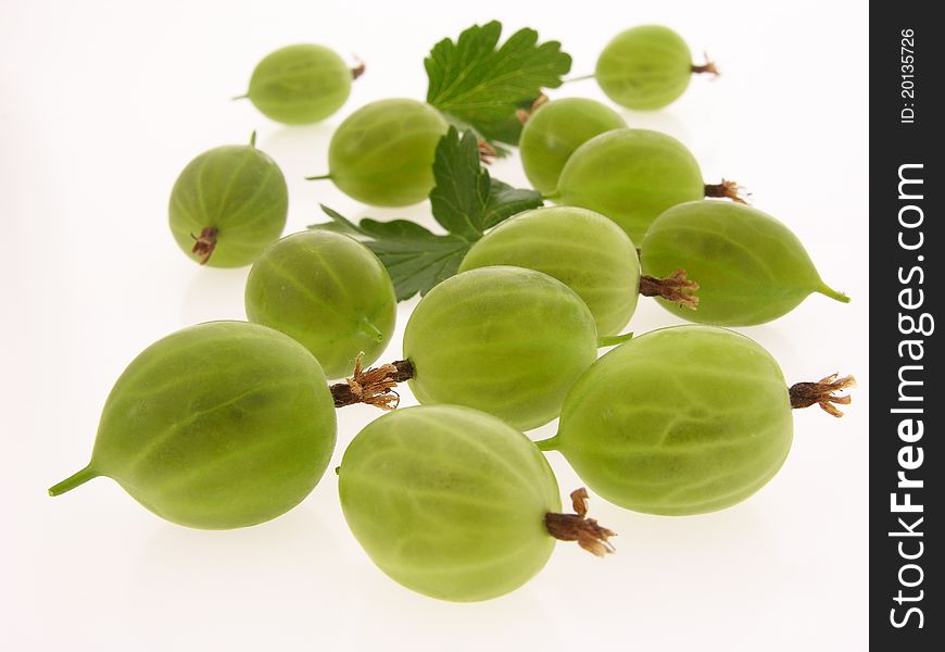 Group of green, ripe gooseberries with leaves