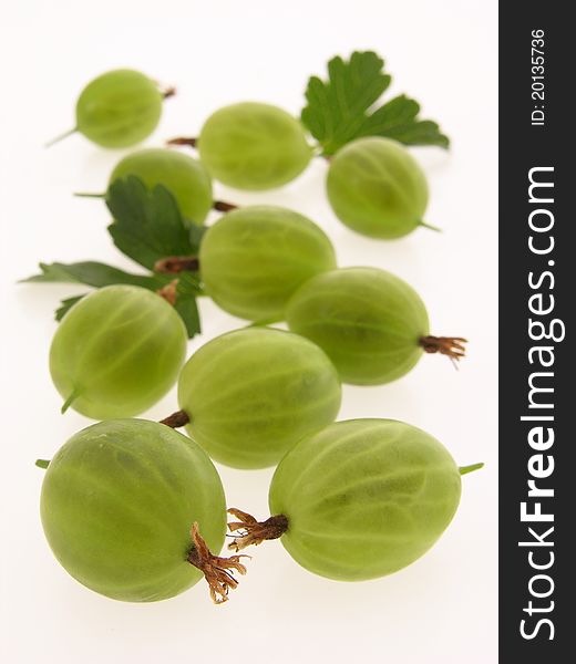 Group of green, ripe gooseberries with leaves