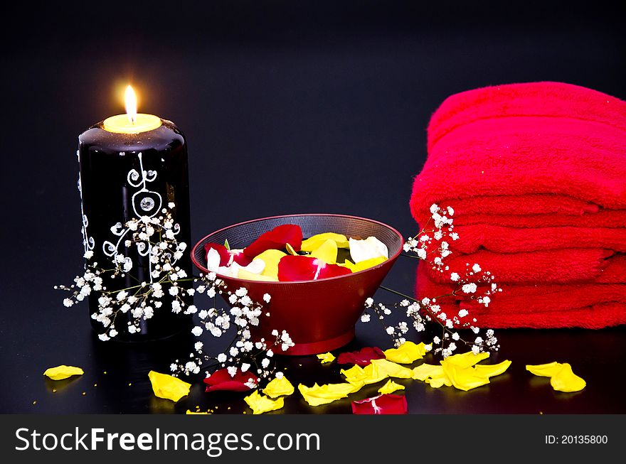 Red towels with flower and candle on black background. Red towels with flower and candle on black background