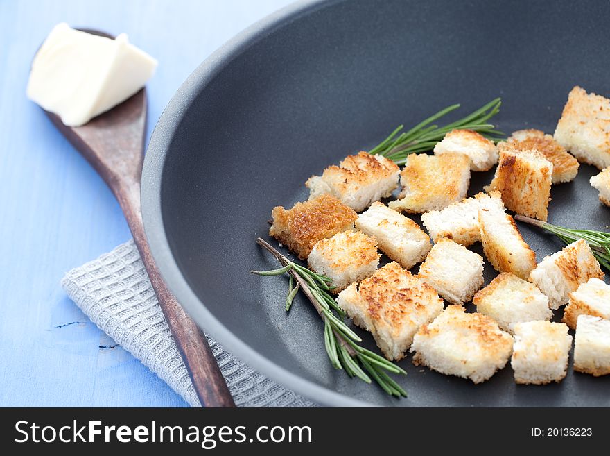 Fresh croutons in a pan with rosemary