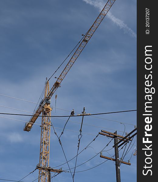 View of a construction crane in downtown of a city. View of a construction crane in downtown of a city