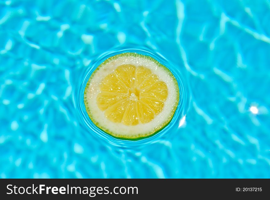 Yellow lemon in a beautiful blue water