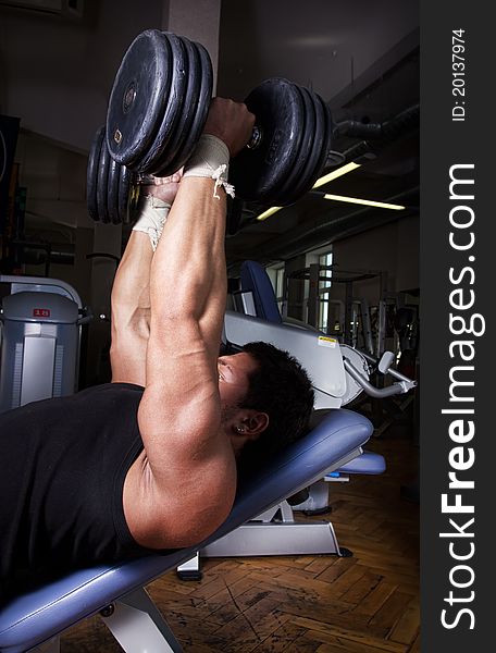 Sportsman lifting heavy dumbbells in gym. Sportsman lifting heavy dumbbells in gym