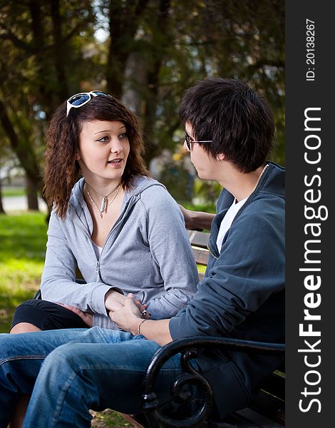 Attractive couple sitting on bench in the park. Attractive couple sitting on bench in the park