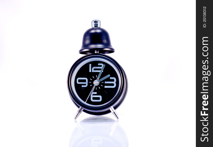 A black alarm clock isolated on white background. A black alarm clock isolated on white background