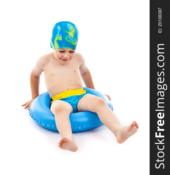 Funny little boy playing with blue life ring in swim caps