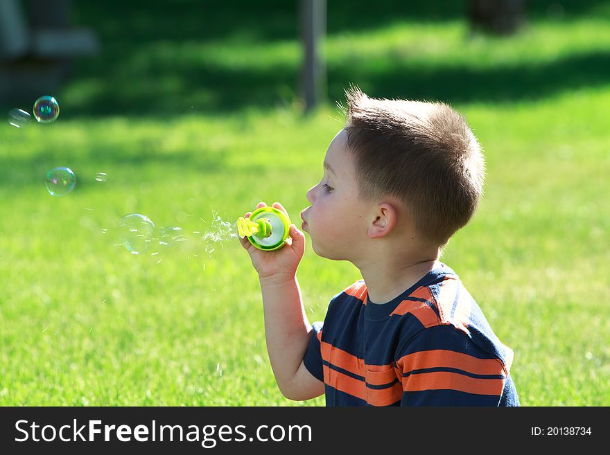 Little Boy Blowing Soap Bubbles