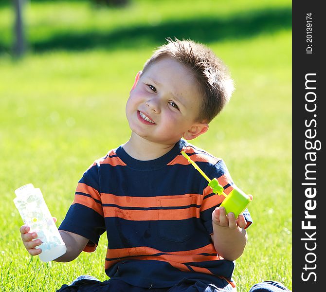 Little boy blowing soap bubbles at the park. Little boy blowing soap bubbles at the park