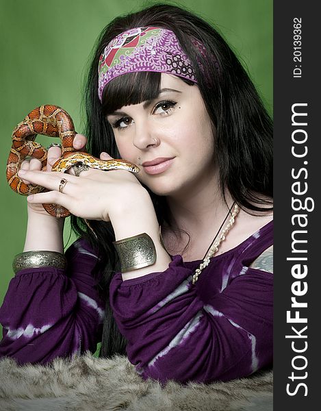 Hippie woman holding tiger corn snake close to face. Hippie woman holding tiger corn snake close to face