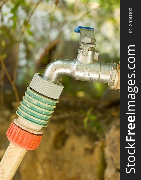 A tap with a hose connector and hose attached to it. A tap with a hose connector and hose attached to it