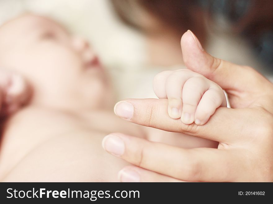 Close-up of baby's hand holding mother's fingerher's. Close-up of baby's hand holding mother's fingerher's