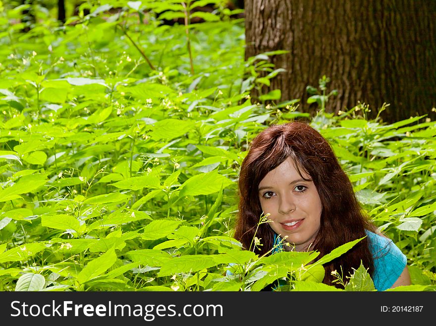 A beautiful young girl hiding in the undergrowth. A beautiful young girl hiding in the undergrowth