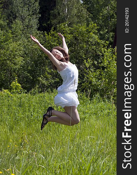 Young happy girl jumping in a meadow. Young happy girl jumping in a meadow