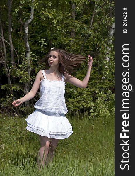 Young girl in a white dress walking in a forest. Young girl in a white dress walking in a forest
