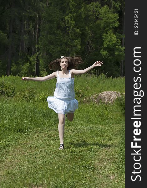 Young happy girl running in a meadow. Young happy girl running in a meadow